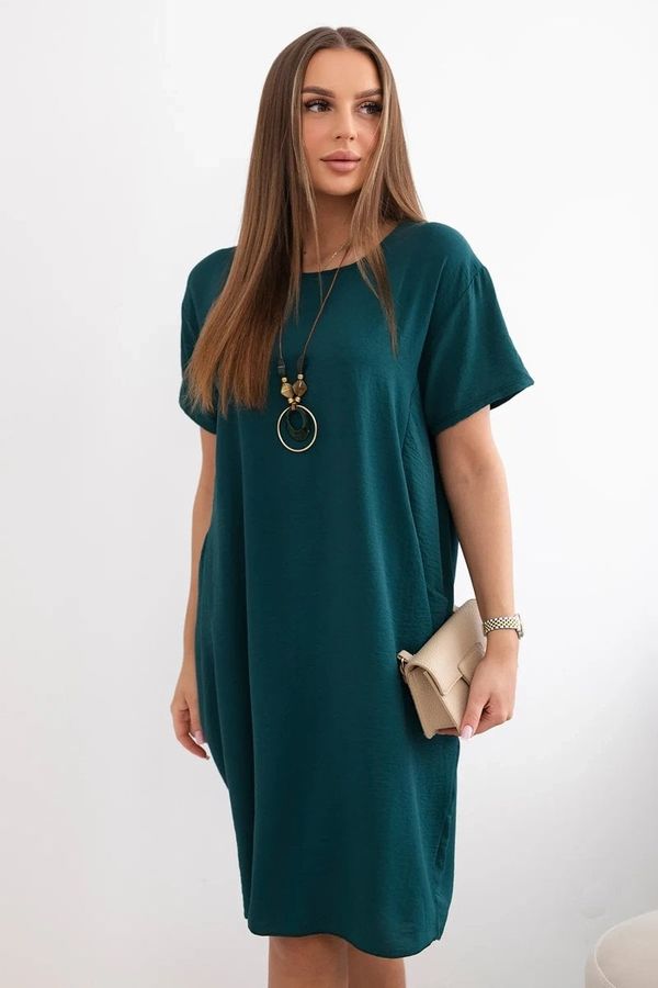 Kesi Dress with pockets and a pendant in dark green